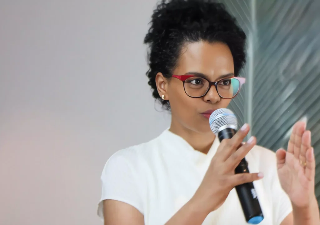 Carla Brasil falando no microfone sobre Cultura de Segurança